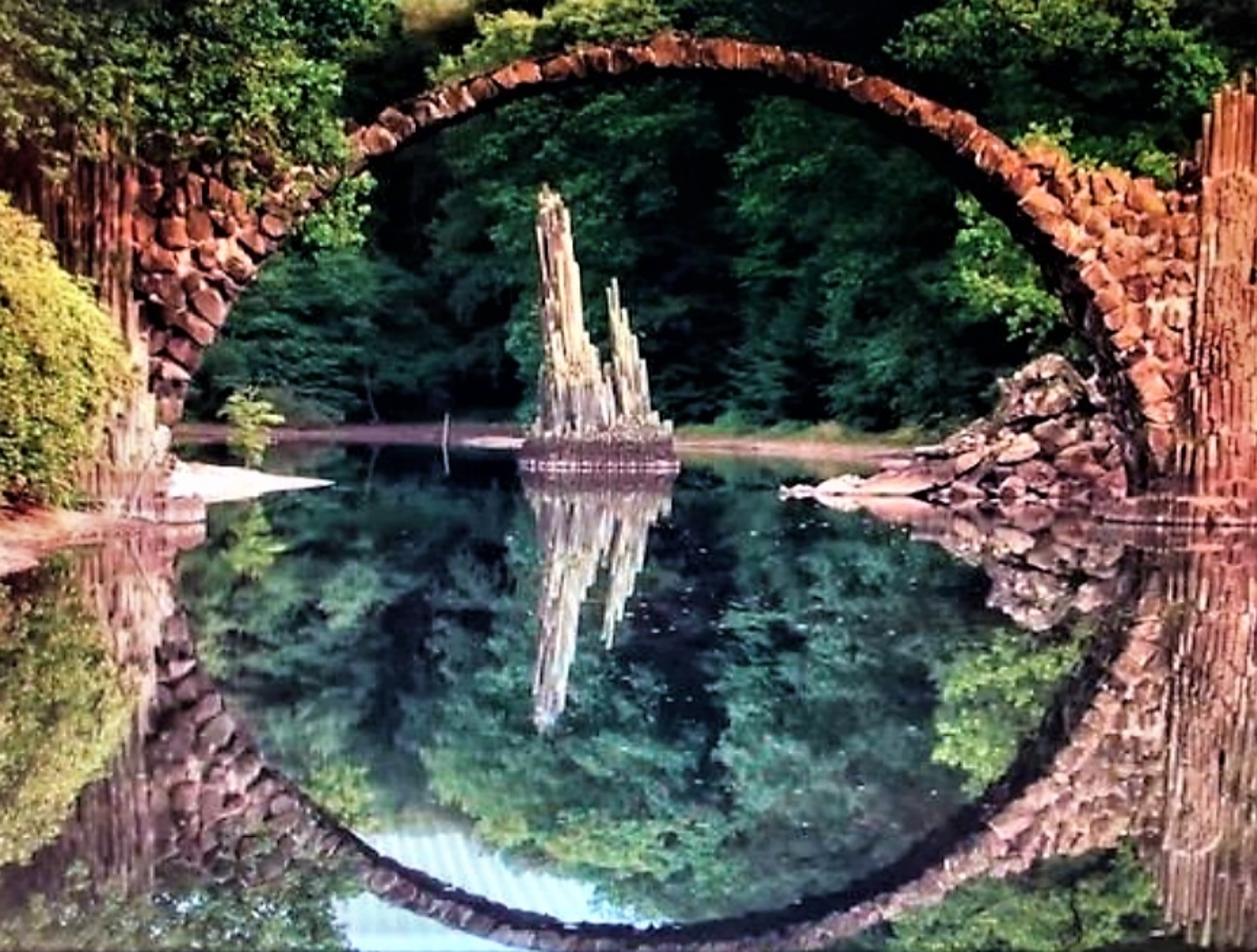 A stone bridge over a body of water

Description automatically generated